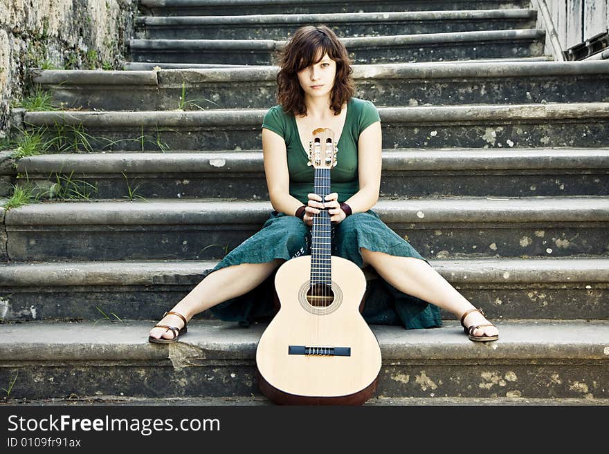 Young female guitarist on antique background. Young female guitarist on antique background