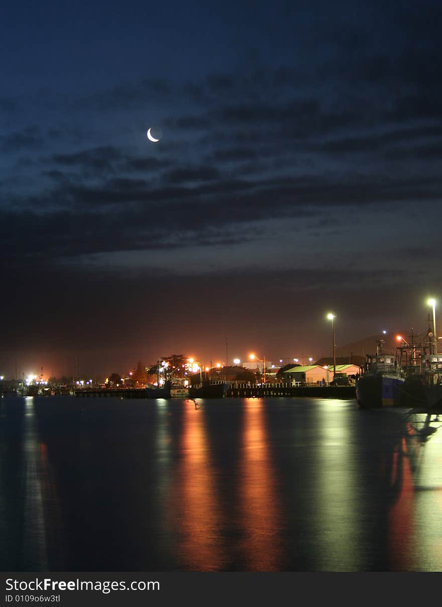 Reflections in calm water of fishing village at night. Reflections in calm water of fishing village at night.