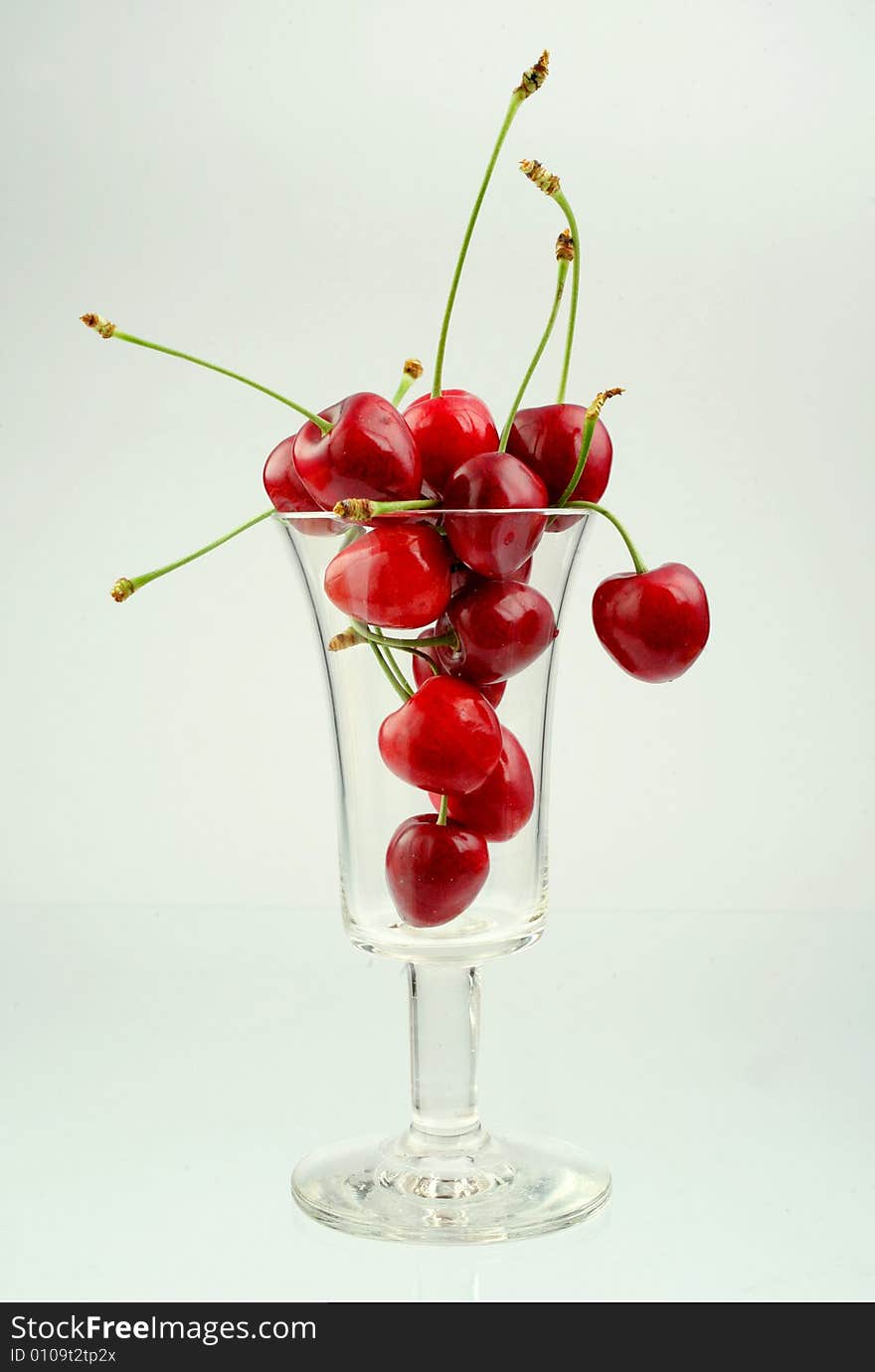 Ripe cherries in a glass on white background. Ripe cherries in a glass on white background