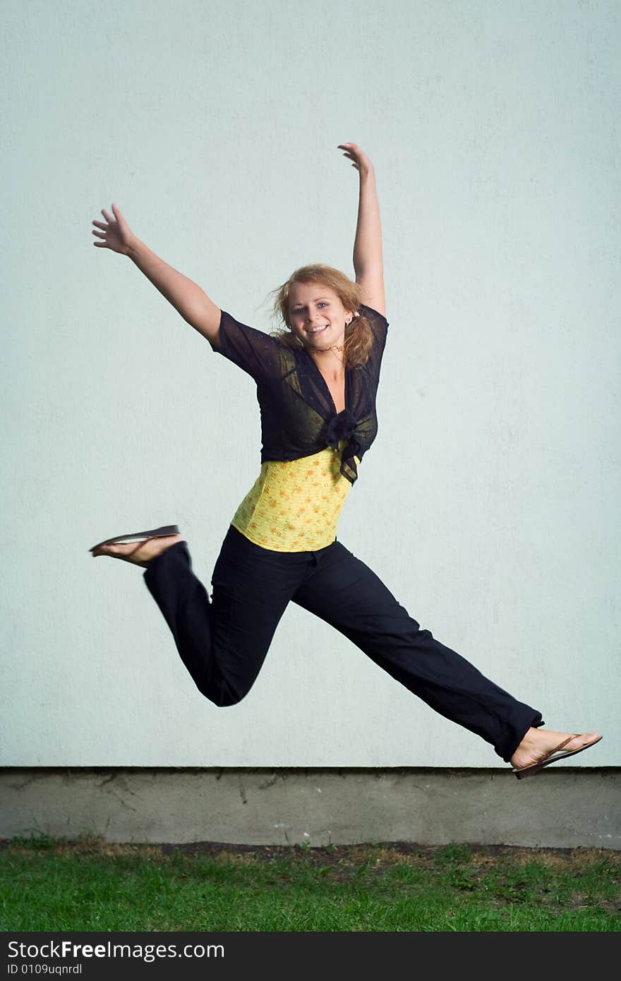 Happy jumping girl against the wall. Happy jumping girl against the wall.