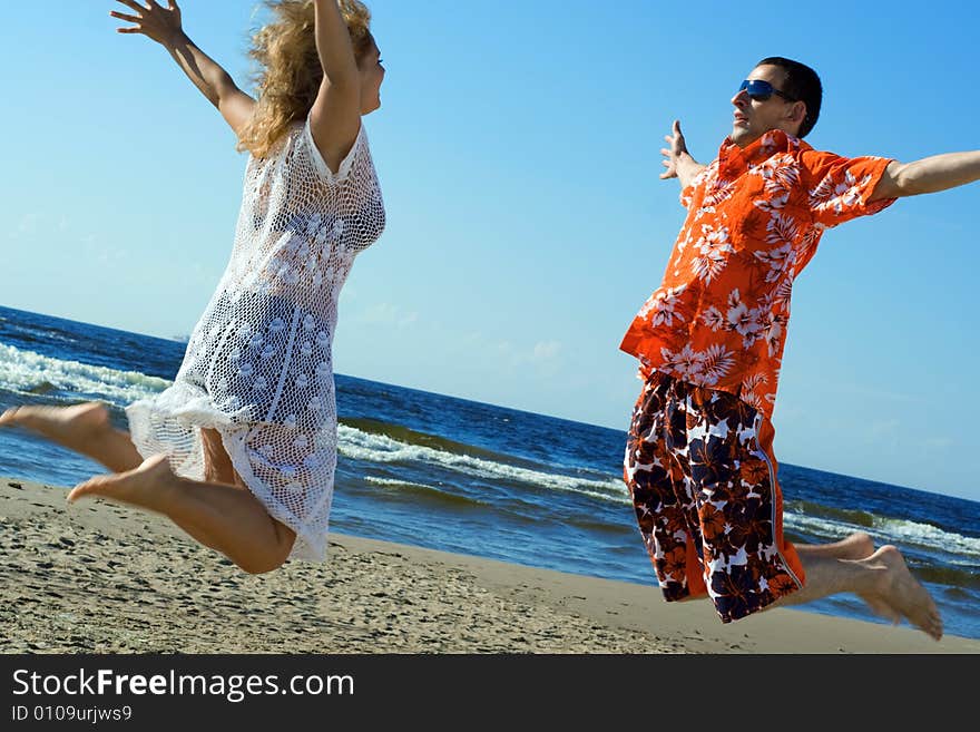 Two young people jumping on the beach. Two young people jumping on the beach.