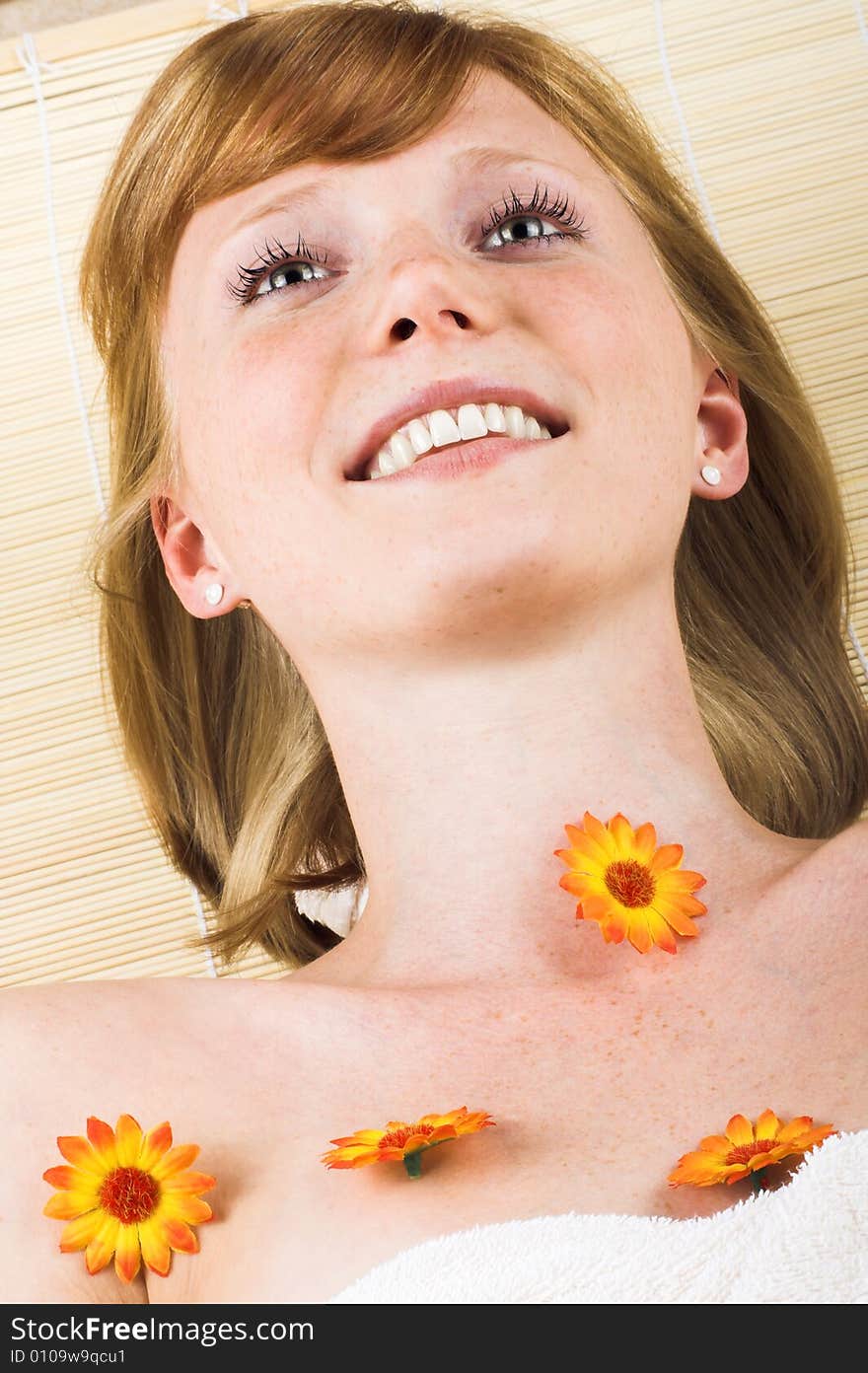 Young beautiful woman in a spa with a towel and flowers. Young beautiful woman in a spa with a towel and flowers