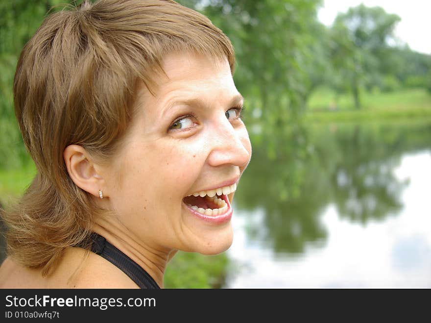 Attractive young woman smiling against a lake