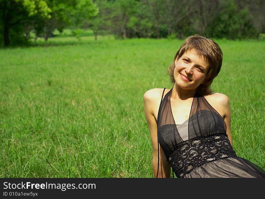 Attractive young woman against green grass. Attractive young woman against green grass