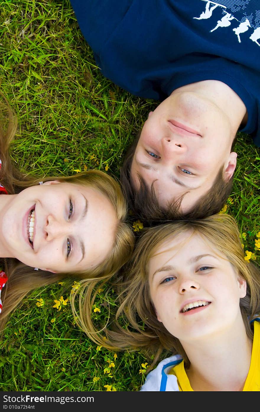 Three happy friends lay on a grass. Three happy friends lay on a grass