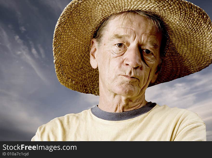 Senior in a straw hat in front of cloudy sky. Senior in a straw hat in front of cloudy sky