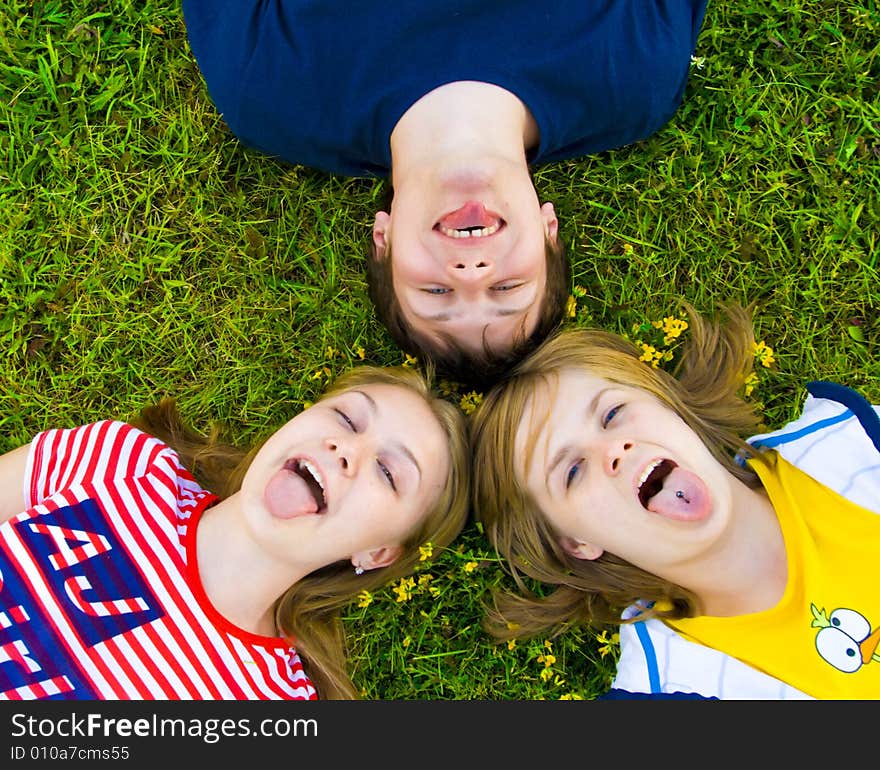 Three friends lay on a green grass. Three friends lay on a green grass