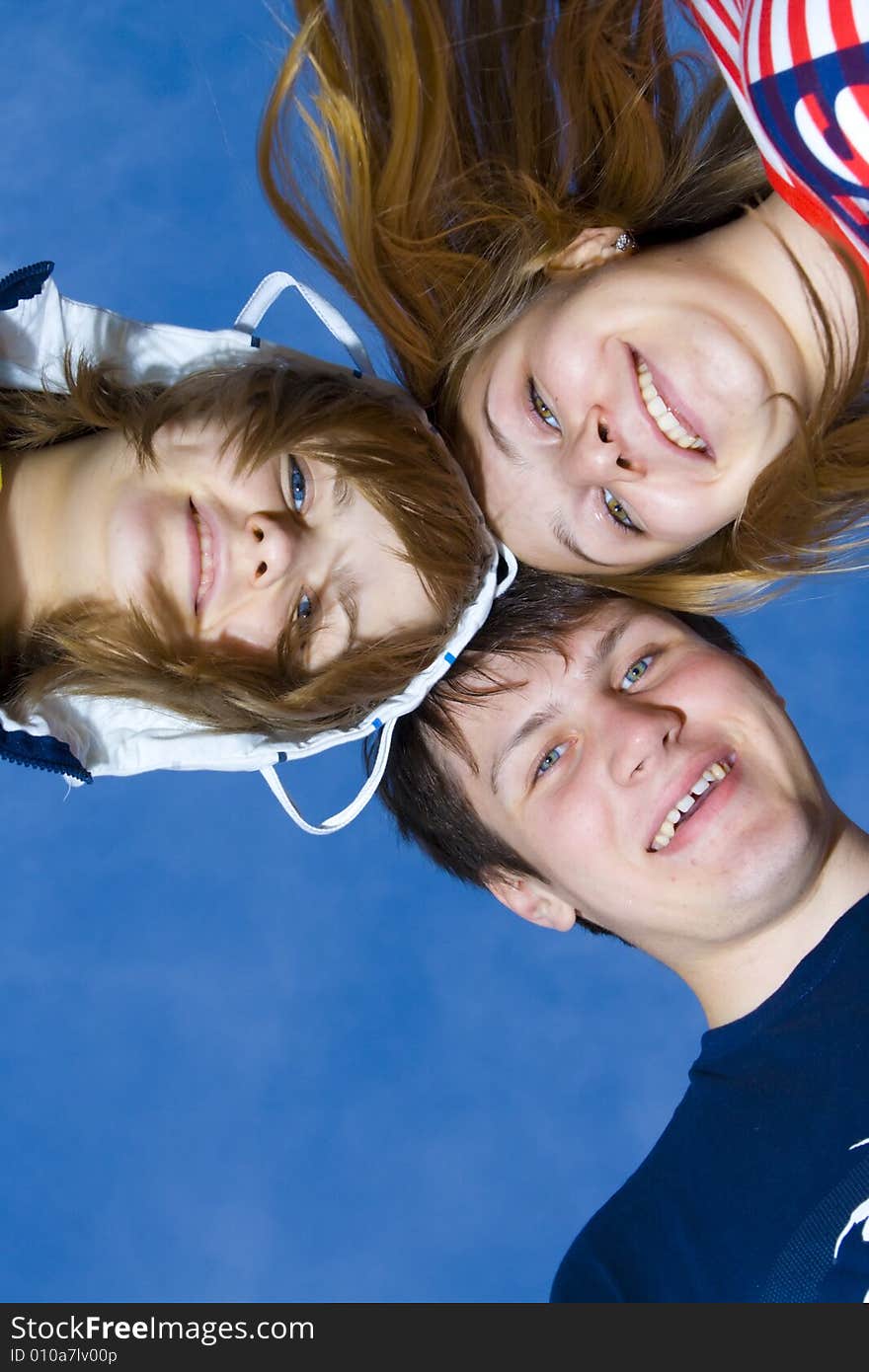 Three friends on a background of the blue sky