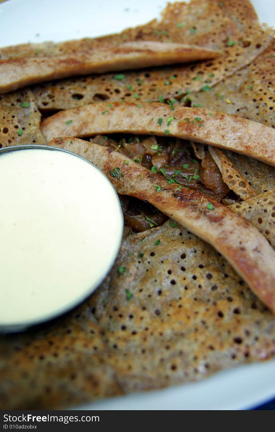 Traditional French crepe with sausage and mustard sauce. Focus at the centre of the image.