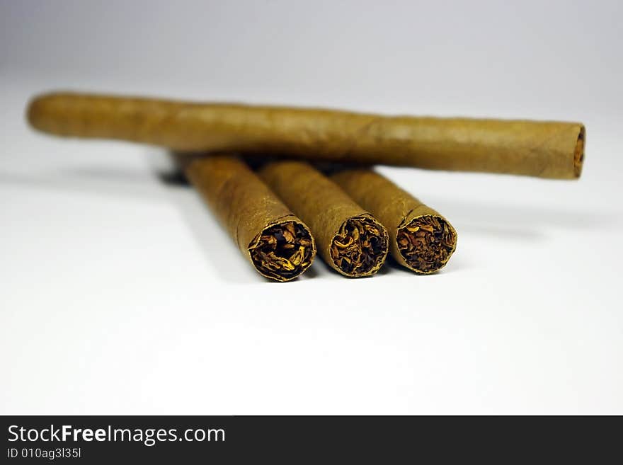 Four cigars on a white and gray background close-up