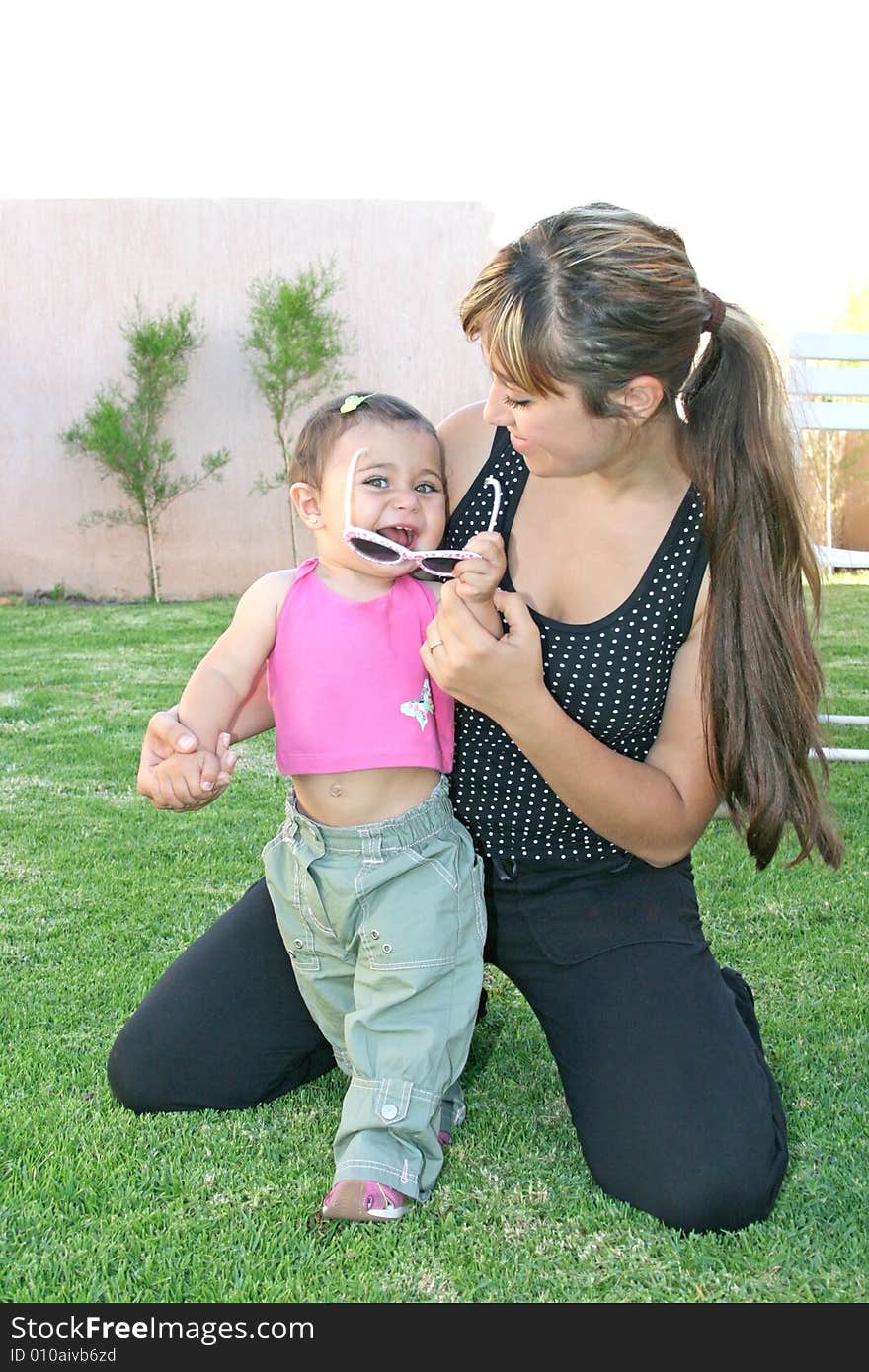 Mother and daughter holding sunglasses.