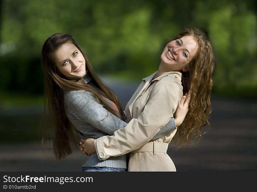 Two girlfriends embrace on street. Two girlfriends embrace on street