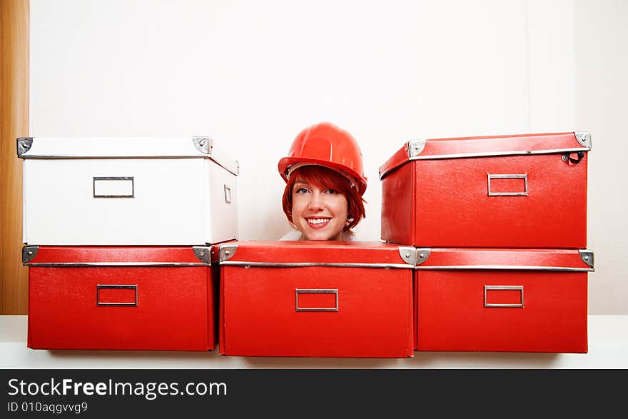 Young female constructor with boxes