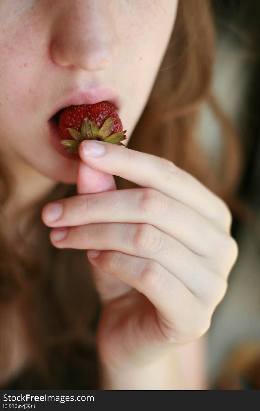 The girl eats a strawberry. The girl eats a strawberry