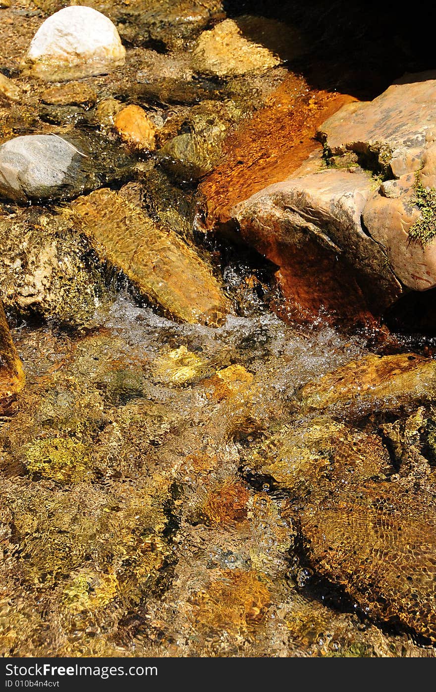 Red rocks in a mountain stream of fresh crystalline water. Red rocks in a mountain stream of fresh crystalline water