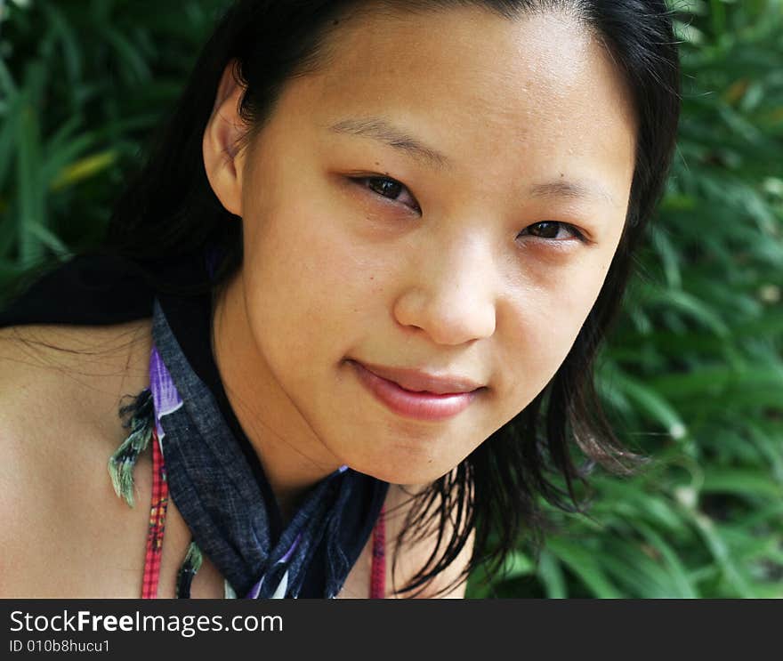 Asian woman in a pretty summer sarong by the pool. Asian woman in a pretty summer sarong by the pool.