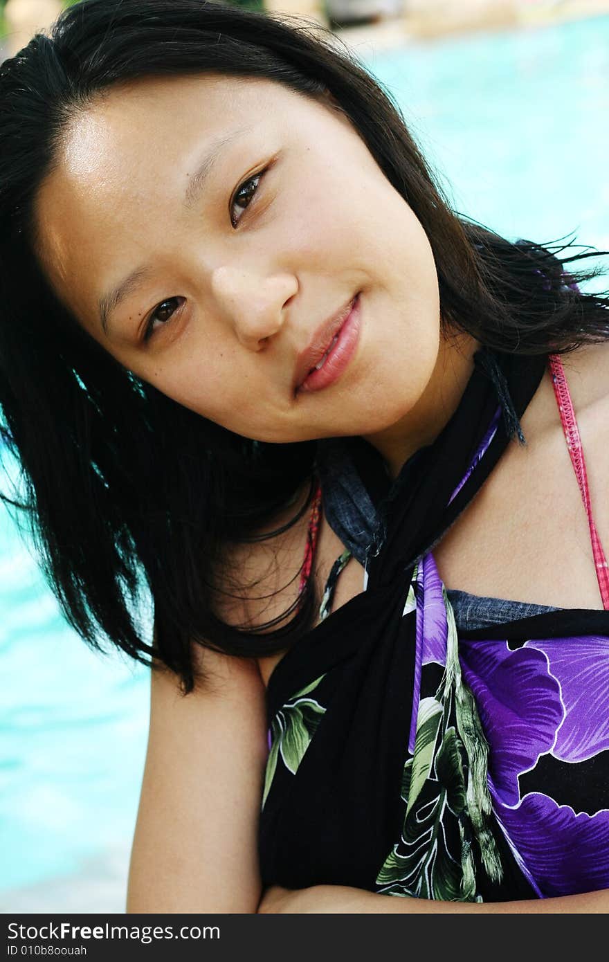 Asian woman in a pretty summer sarong by the pool. Asian woman in a pretty summer sarong by the pool.