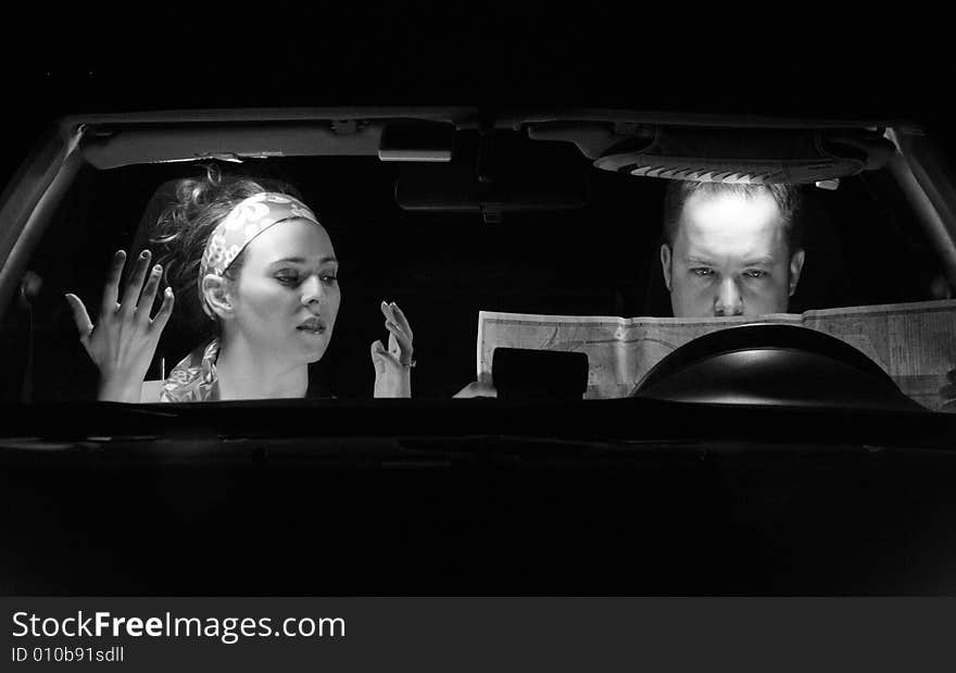 A couple in the car look at a map. A couple in the car look at a map