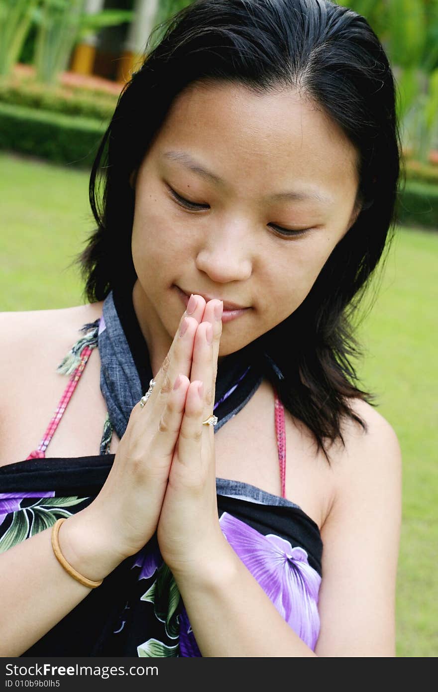 Asian woman giving a traditional Thai greeting (wai).