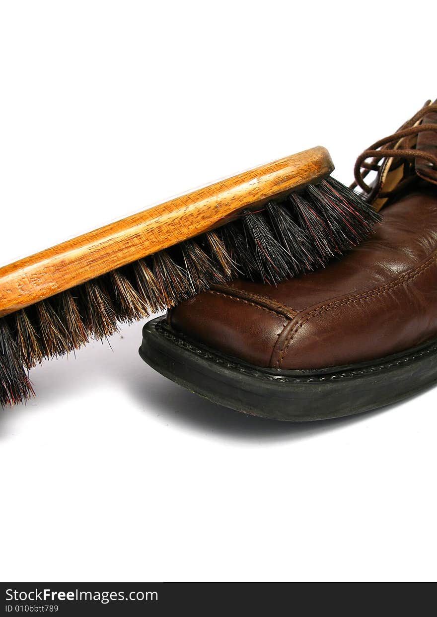 Clean brush and brown men shoe in isolated background