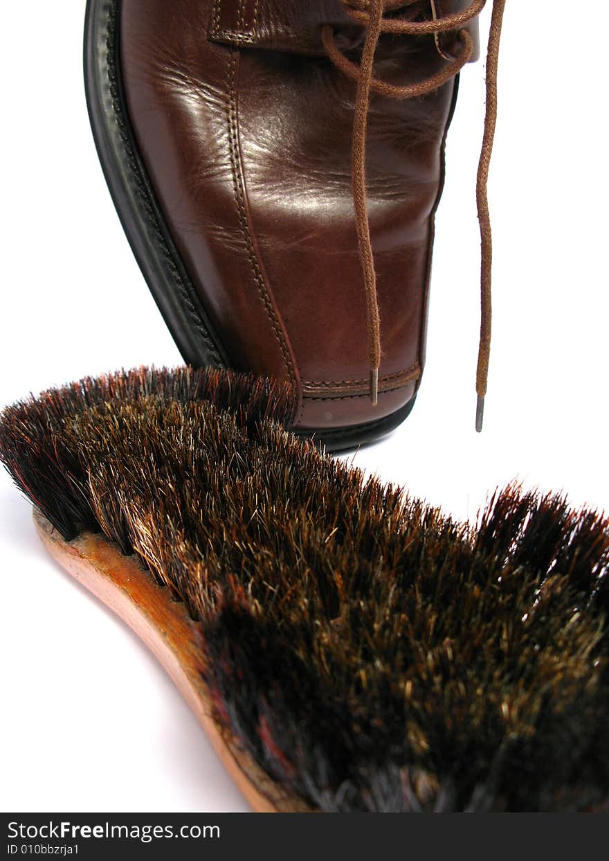 Clean brush and brown men shoe in isolated background