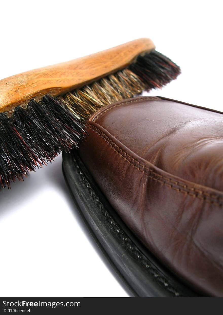 Clean brush and brown men shoe in isolated background