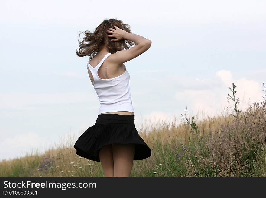 A beautiful girl dancing on the field. A beautiful girl dancing on the field