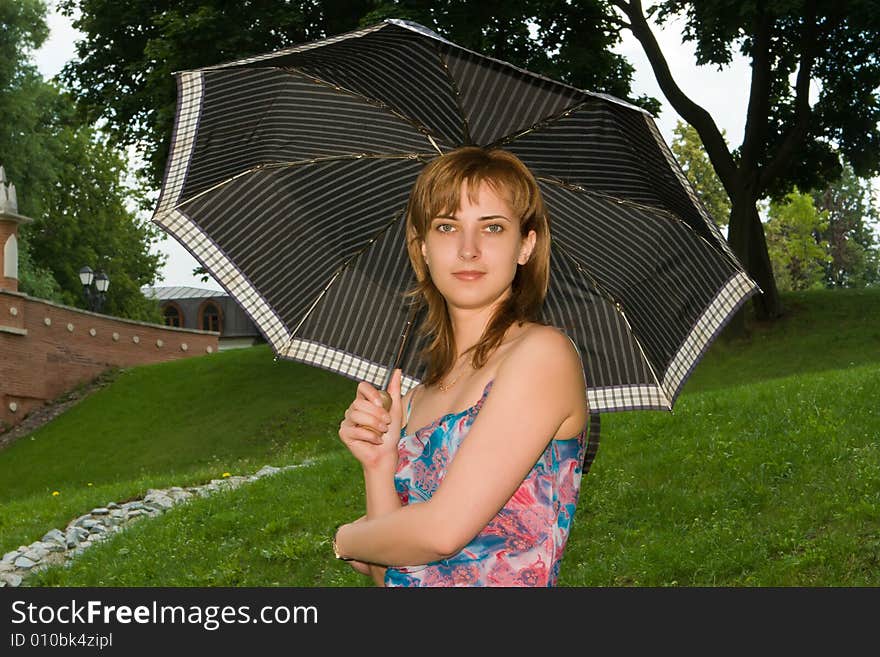 Girl under a umbrella on a background of the nature