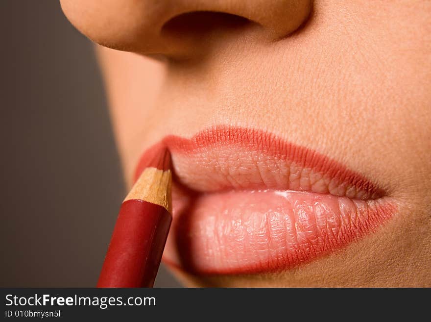 Young caucasian model applying cosmetics with pencil. Young caucasian model applying cosmetics with pencil