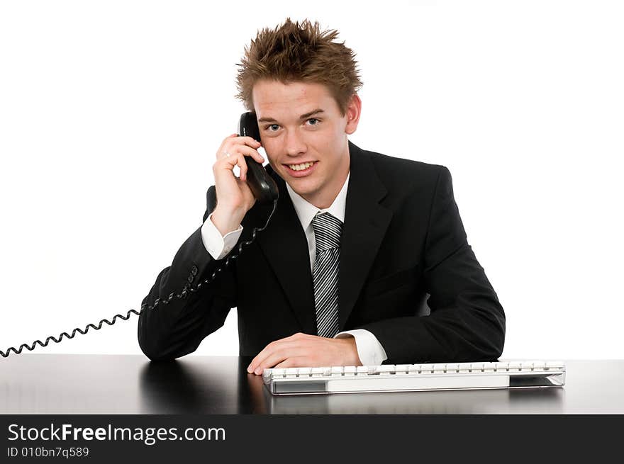 A young businessman on the phone in his office. A young businessman on the phone in his office