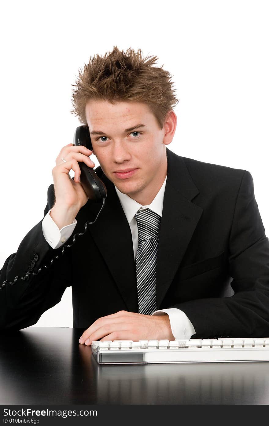 A young businessman on the phone in his office. A young businessman on the phone in his office