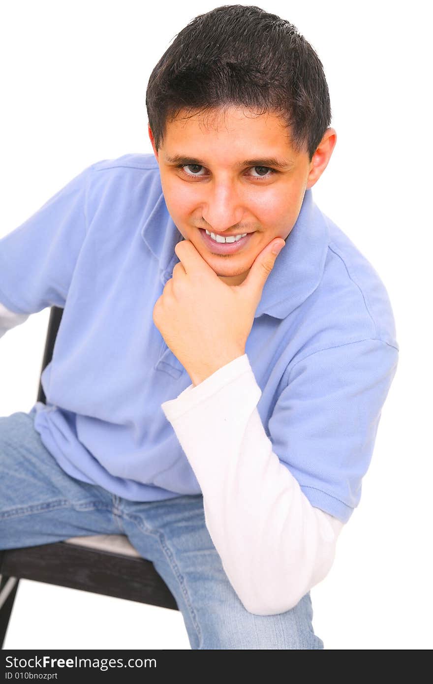 Sitting teenager holding his chin and smiling. isolated on white background. Sitting teenager holding his chin and smiling. isolated on white background