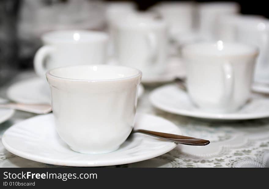 White coffee cups on saucers with shallow focus