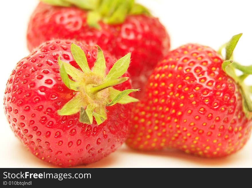 Three fresh strawberries on a white background. Three fresh strawberries on a white background