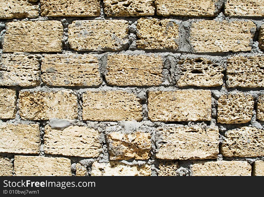 Wall from a rough yellow brick. background