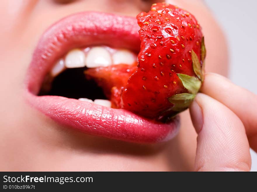 Woman's mouth with red strawberry