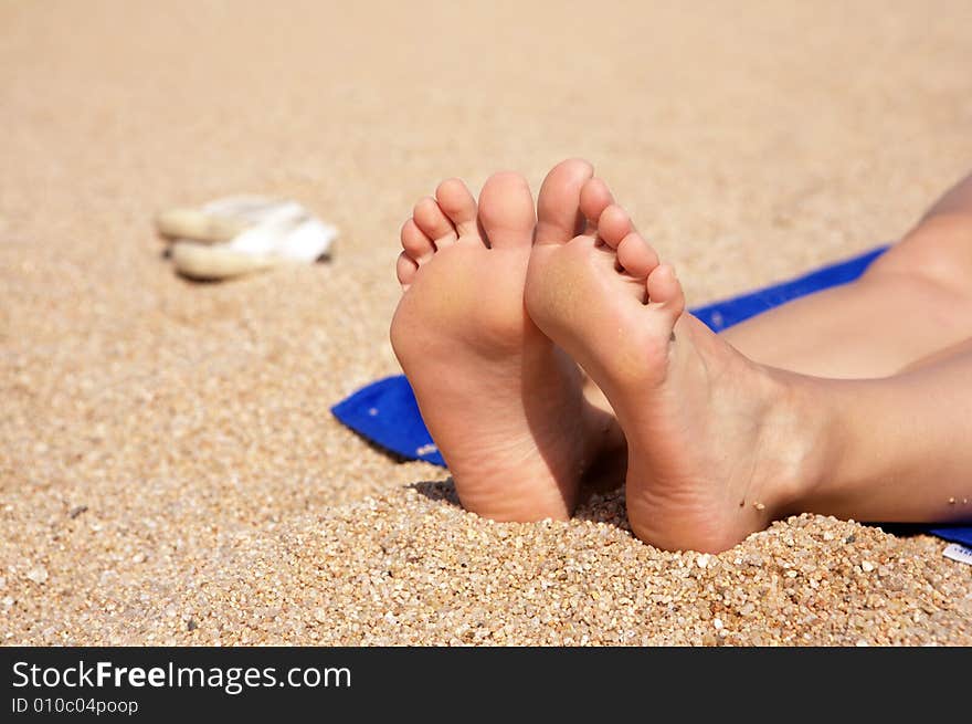 A photo of women's feet on the sand