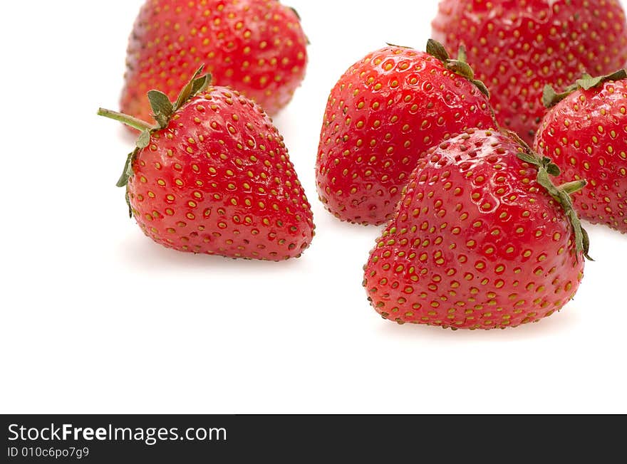 Juicy fruits of a ripe strawberry on a white background. Juicy fruits of a ripe strawberry on a white background