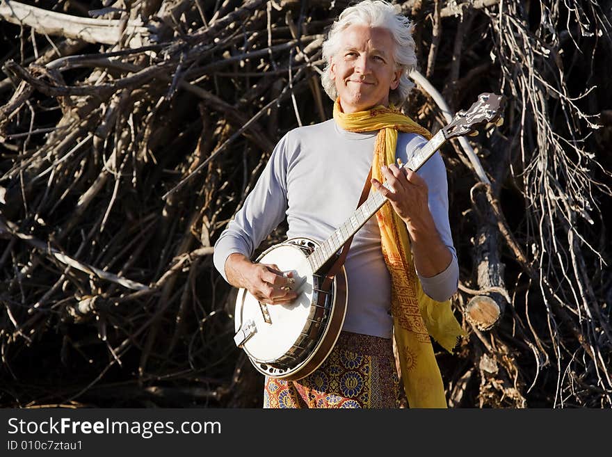 Banjo Player in Front of a Big Pile of Wood