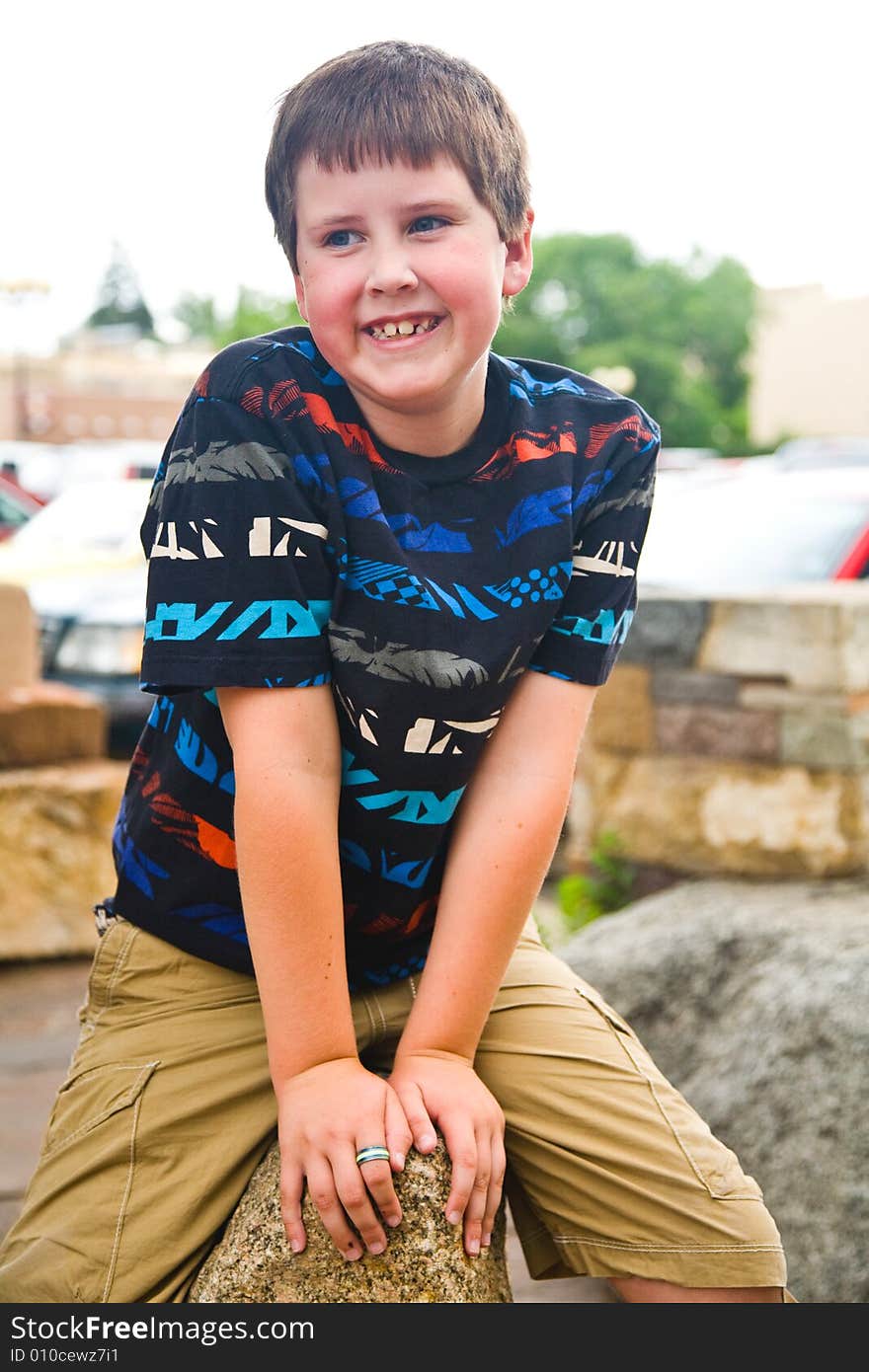 Young happy boy in a mulitcolored shirt smiling. Young happy boy in a mulitcolored shirt smiling