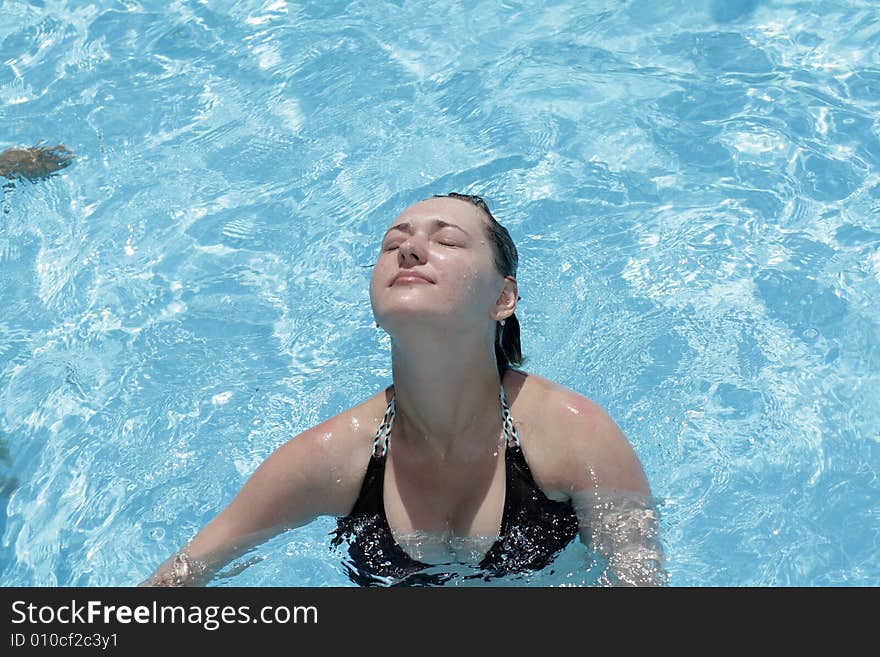 The girl throw back her head in pool. The girl throw back her head in pool