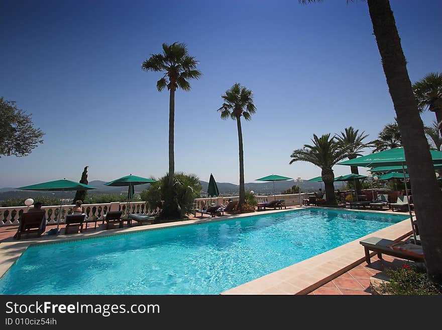 Poolside at bormes les mimosas, french riviera, france, waves, lounge chair, parasol  and palm tree. Poolside at bormes les mimosas, french riviera, france, waves, lounge chair, parasol  and palm tree