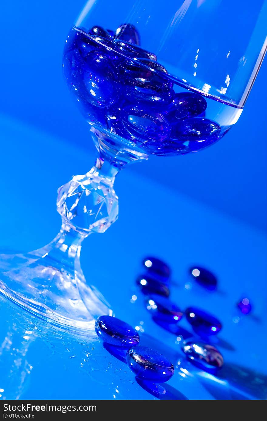 Wine glass with water and blue pills