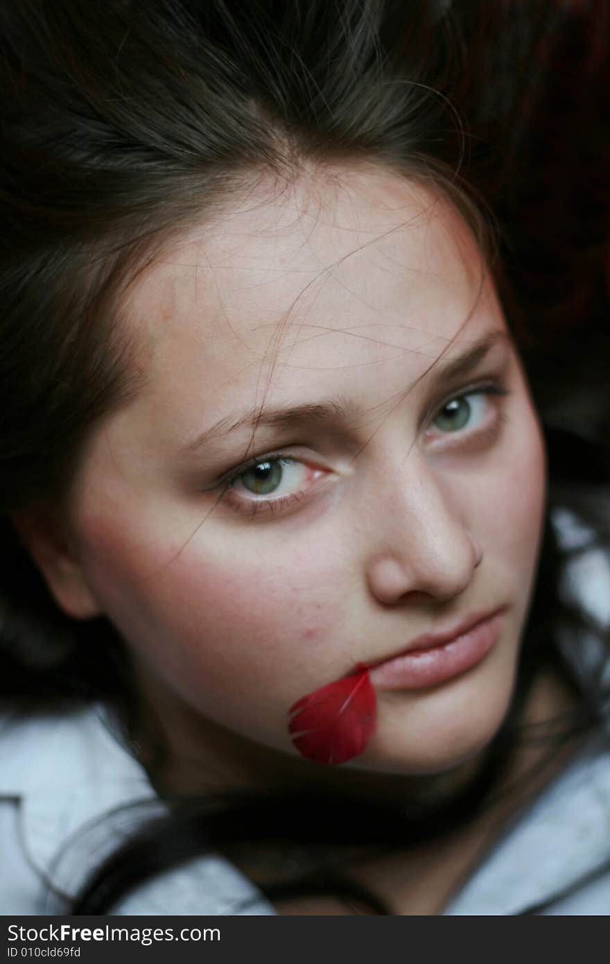 The brunette with a red feather in a mouth