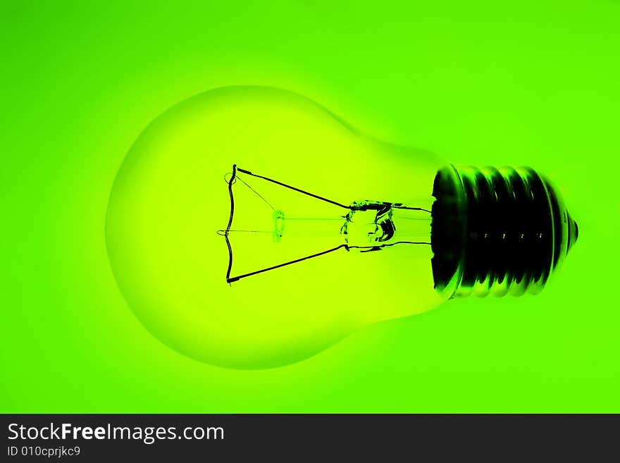 Transparent electric lamp bulb on green background