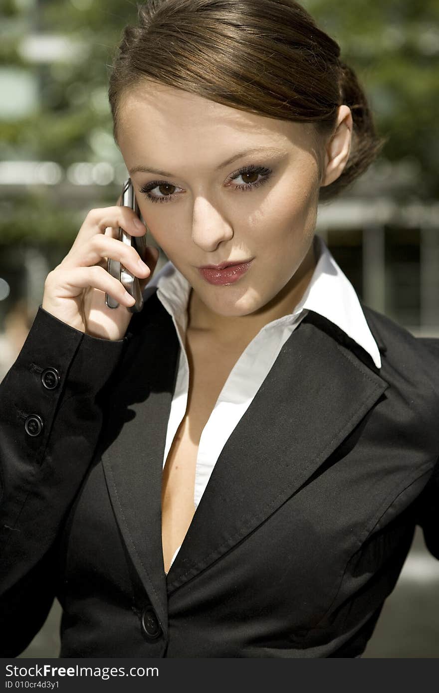 Young and attractive businesswoman talking on the mobile outside. Young and attractive businesswoman talking on the mobile outside