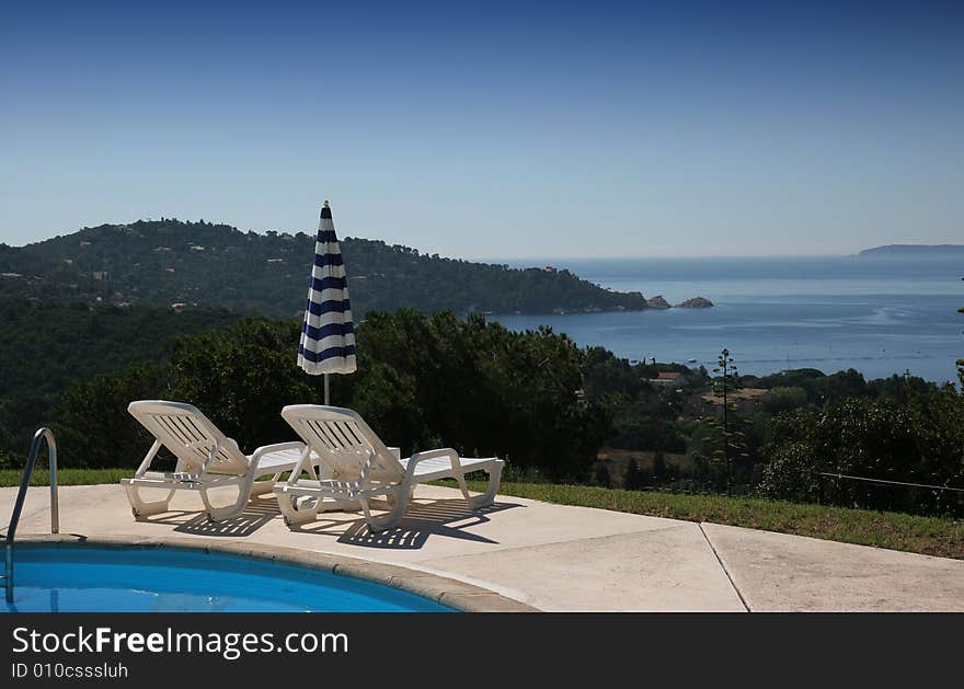 Poolside on the sea at le lavandou azur hotel  french riviera, france, with cape. Poolside on the sea at le lavandou azur hotel  french riviera, france, with cape