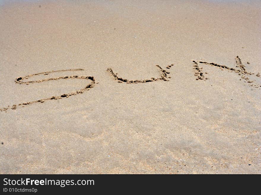 The Word SUN Written In Sand