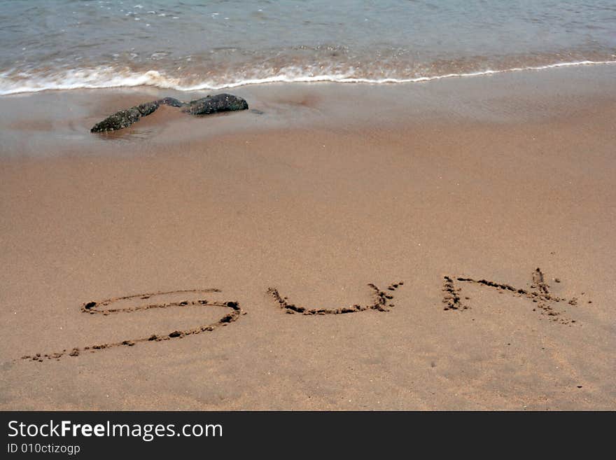 The Word SUN Written In Sand