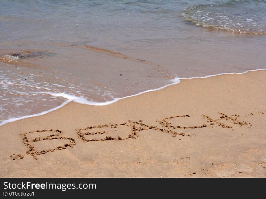 The Word BEACH Written In Sand